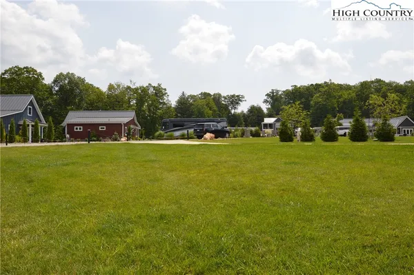 a view of a house with a big yard and large trees
