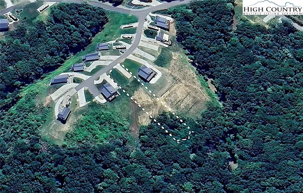an aerial view of residential house with outdoor space and trees all around