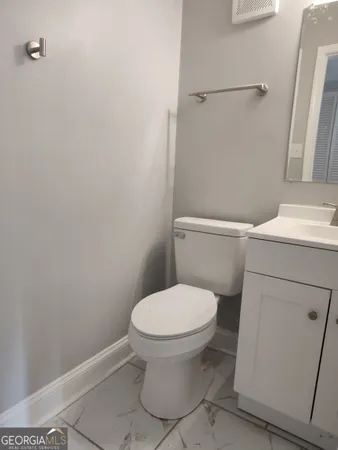 a white toilet sitting next to a bathroom sink
