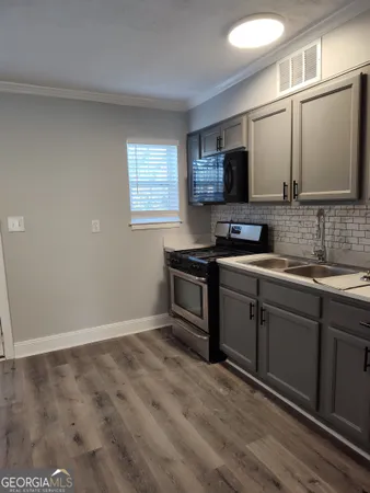 a kitchen with a sink stove and microwave
