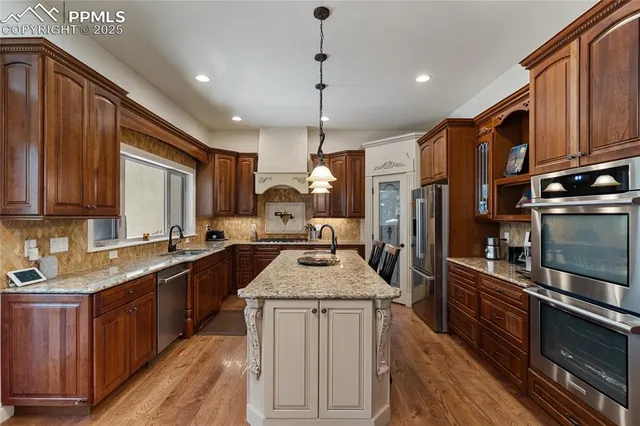 a kitchen with granite countertop a sink cabinets and stainless steel appliances