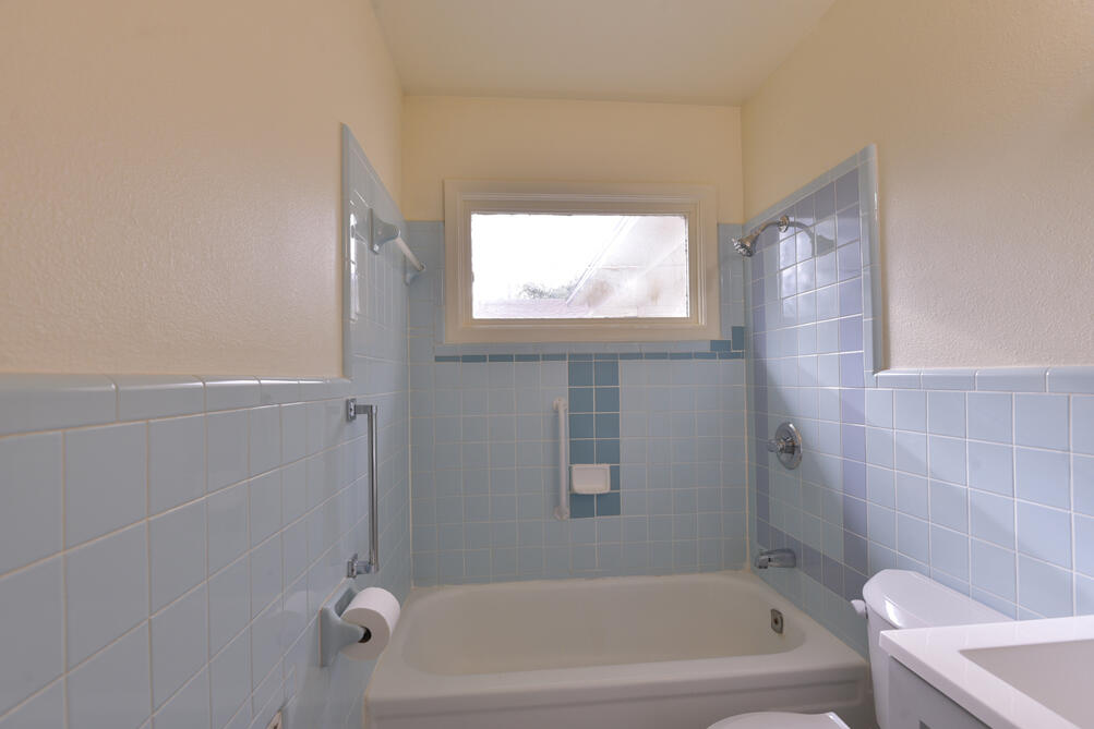 3013 2nd Street Lubbock, TX 79415 - Photo 13 of 21 a bathroom with a bathtub and window