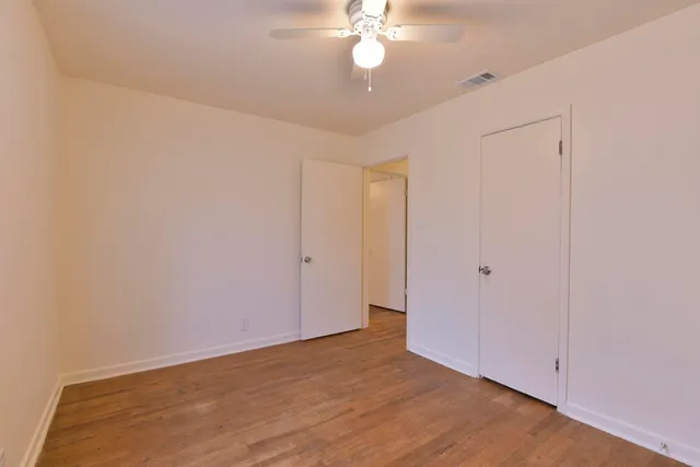 a view of an empty room with a chandelier fan