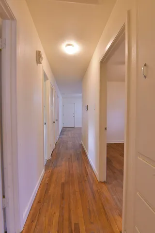 a view of a hallway with wooden floor