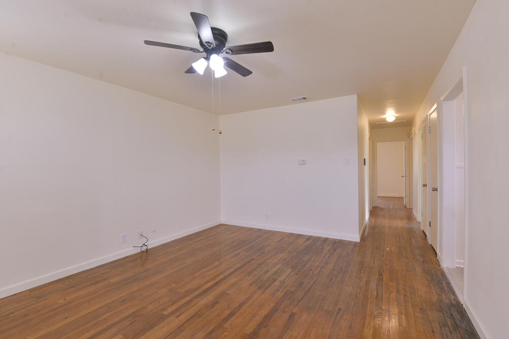 3013 2nd Street Lubbock, TX 79415 - Photo 2 of 21 a view of a big room with wooden floor and a ceiling fan