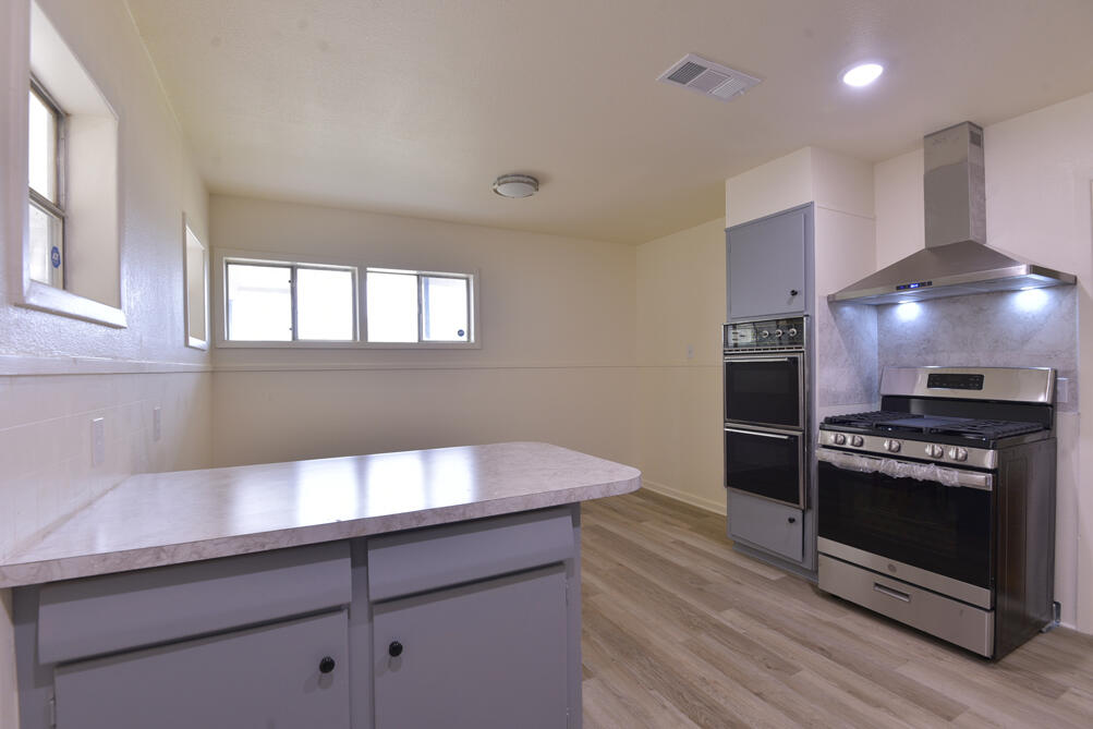 3013 2nd Street Lubbock, TX 79415 - Photo 6 of 21 a kitchen with granite countertop a stove and a refrigerator