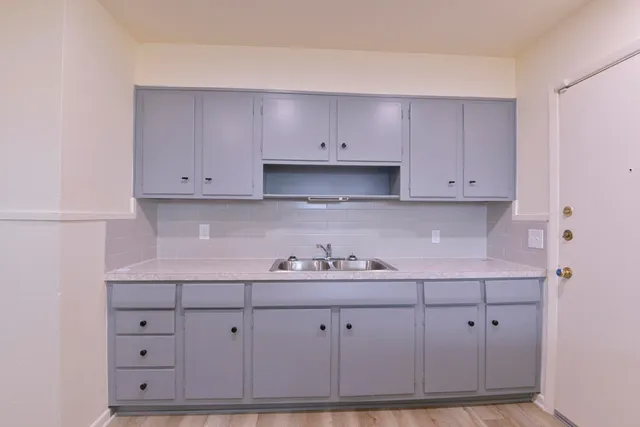 a kitchen with white cabinets and a sink