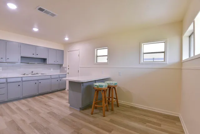 a kitchen with a sink cabinets and wooden floor