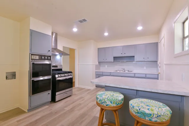 a kitchen with stainless steel appliances granite countertop a stove a refrigerator and a wooden floors