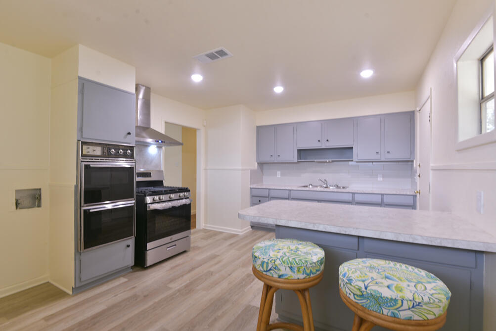3013 2nd Street Lubbock, TX 79415 - Photo 10 of 21 a kitchen with stainless steel appliances granite countertop a stove a refrigerator and a wooden floors