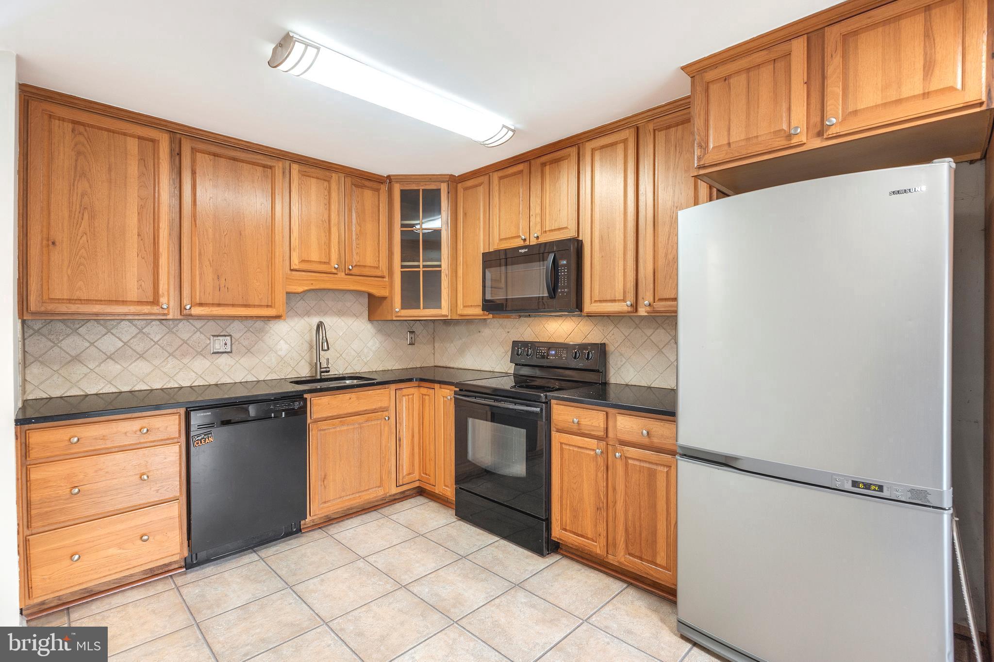 7740 Notley Road Pasadena, MD 21122 - Photo 14 of 46 a kitchen with granite countertop cabinets stainless steel appliances and a counter space