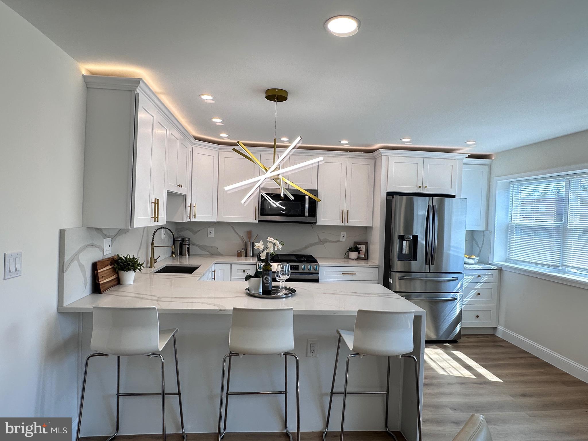 3204 Belgreen Road Philadelphia, PA 19154 - Photo 8 of 27 a kitchen with stainless steel appliances a sink a stove a refrigerator cabinets and chairs