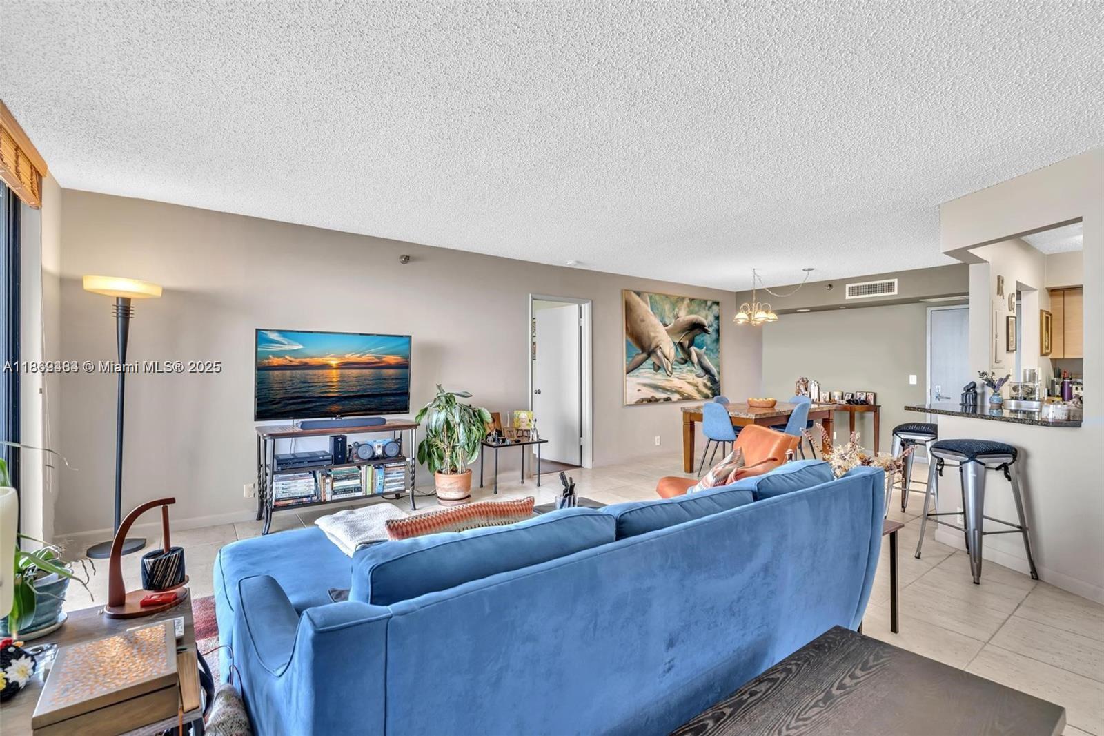 3300 Northeast 191st Street, Unit LP04 Aventura, FL 33180 - Photo 9 of 16 a living room with furniture and a flat screen tv