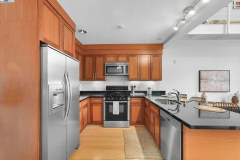 a kitchen with stainless steel appliances granite countertop a stove a sink and a microwave
