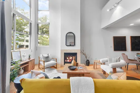 a living room with furniture a fireplace and a large window