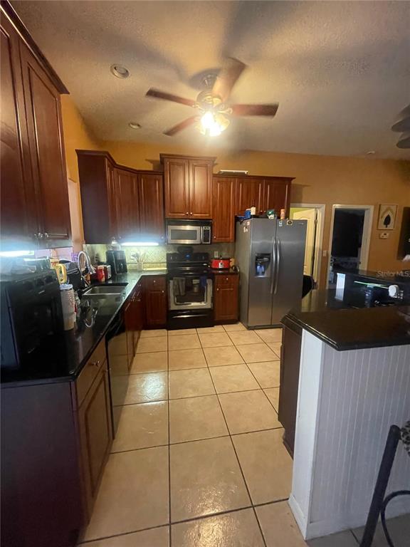 396 Kettering Road Deltona, FL 32725 - Photo 10 of 25 a kitchen with refrigerator and chairs