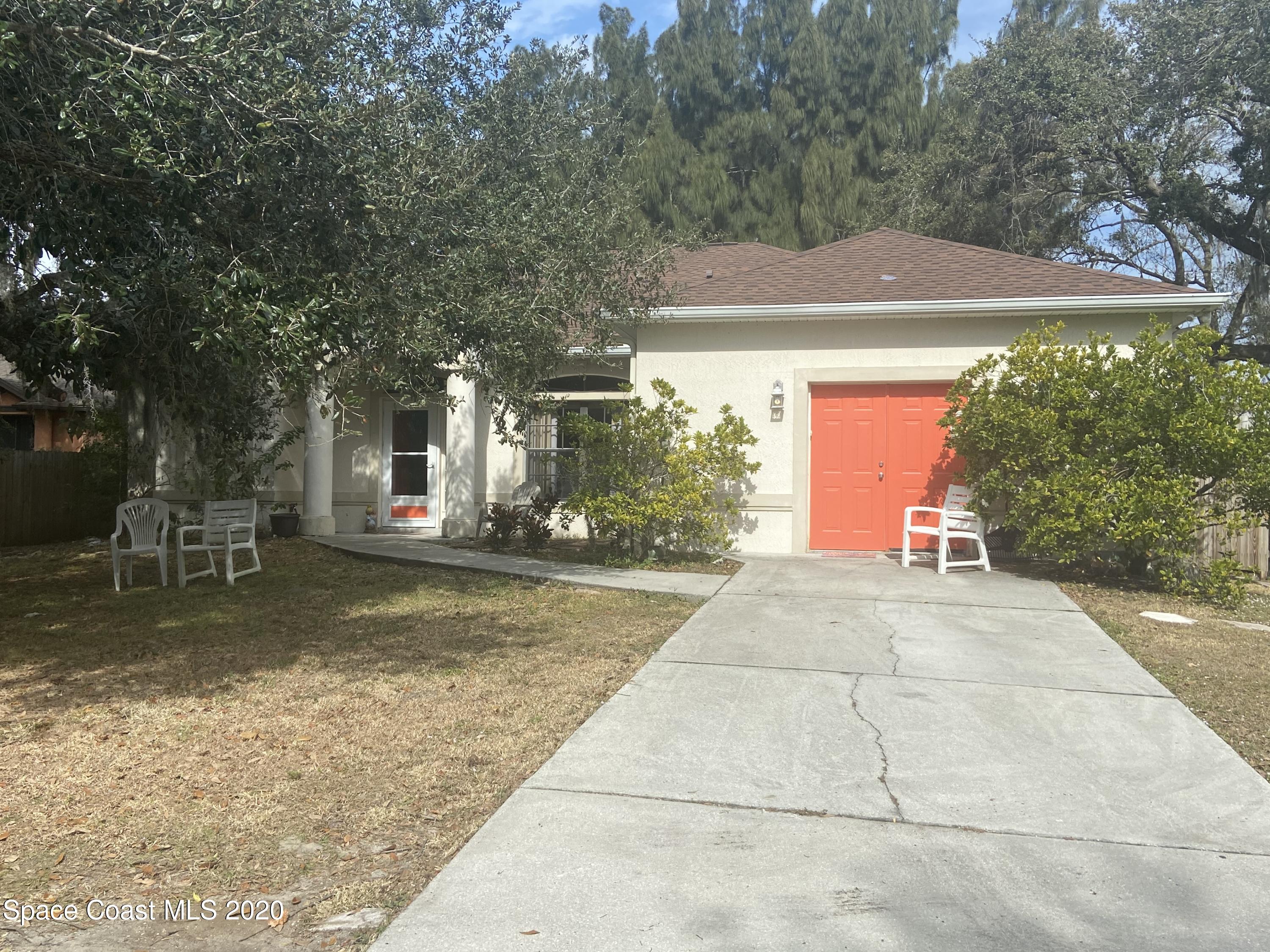 3150 Aurora Road Melbourne, FL 32934 - Photo 1 of 8 a front view of a house with a yard and garage