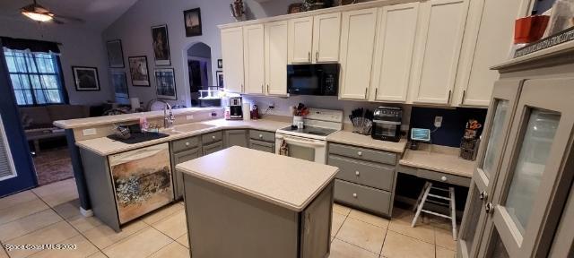 3150 Aurora Road Melbourne, FL 32934 - Photo 3 of 8 a kitchen with stainless steel appliances granite countertop a stove refrigerator sink and microwave