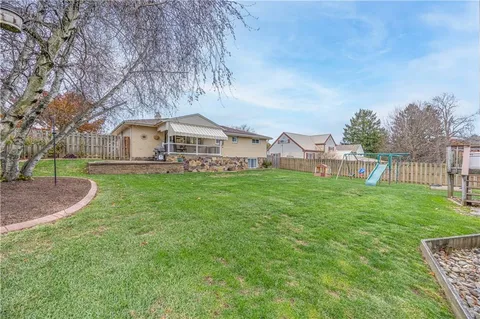 a view of a house with a yard and sitting area