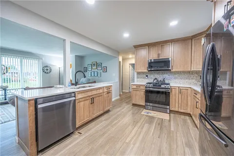 a kitchen with stainless steel appliances kitchen island granite countertop a stove a sink and a refrigerator
