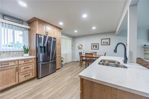 a kitchen with stainless steel appliances a refrigerator sink and wooden floor