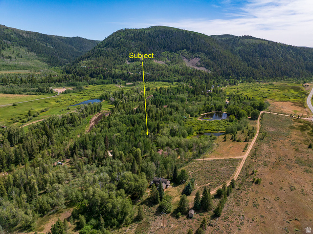 5958 Bull Moose Road Kamas, UT 84036 - Photo 2 of 25 Expansive property featuring a mountainous backdrop, mature tree coverage, and a natural pond