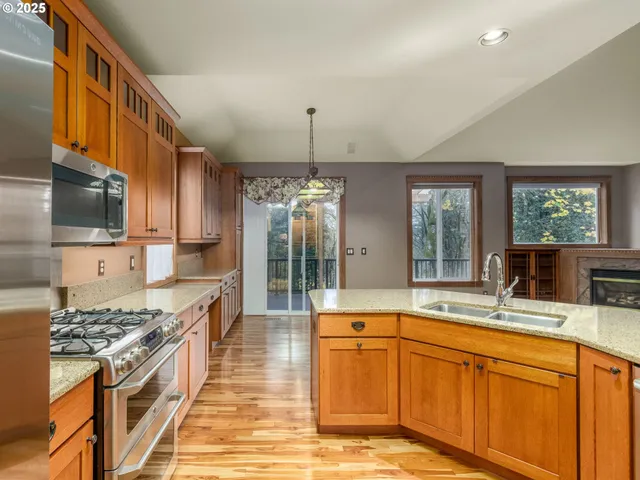 a kitchen with stainless steel appliances granite countertop a sink stove and refrigerator