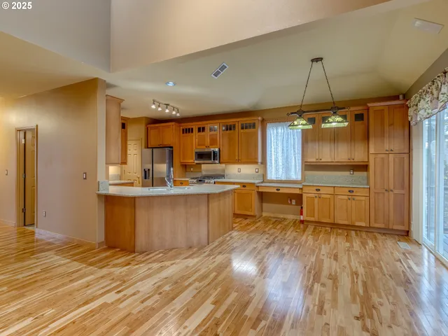 a kitchen with a refrigerator sink and wooden cabinets