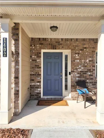 a living room with a fireplace furniture a ceiling fan and a window