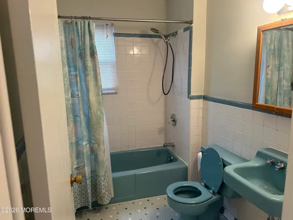 a bathroom with a shower a toilet and a sink