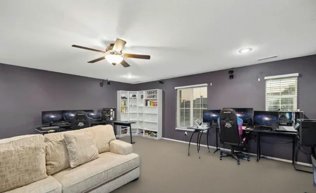 a living room with furniture and a ceiling fan