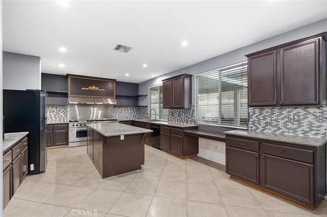 a kitchen with stainless steel appliances granite countertop a sink counter space cabinets and a large window