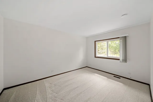 an empty room with a window and a ceiling fan