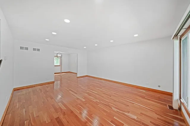 a view of empty room with wooden floor