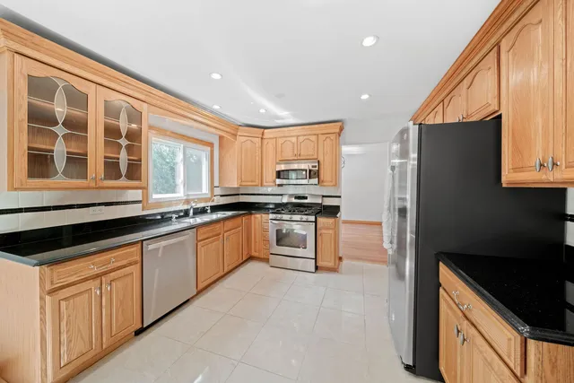 a kitchen with kitchen island a counter top space stainless steel appliances and cabinets