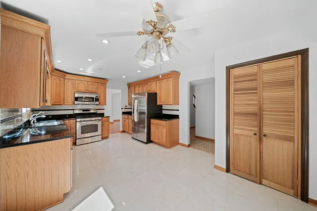 a kitchen with stainless steel appliances kitchen island granite countertop a refrigerator a stove a sink a washer and dishwasher next to a window