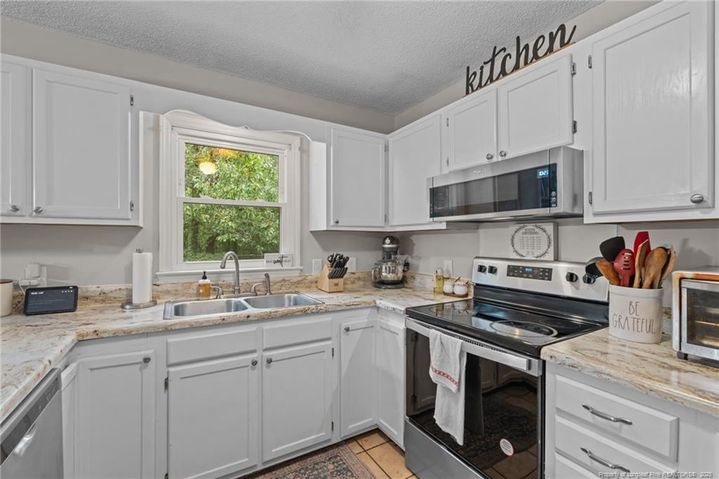 76 North Hillside Drive Spring Lake, NC 28390 - Photo 11 of 50 a kitchen with cabinets appliances a sink and a window