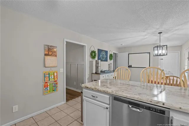 a kitchen with granite countertop cabinets a stove and a dining table
