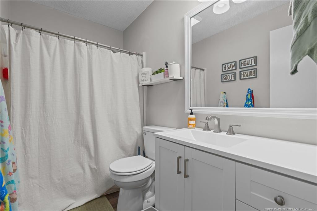 76 North Hillside Drive Spring Lake, NC 28390 - Photo 22 of 50 a bathroom with a sink a toilet and a mirror