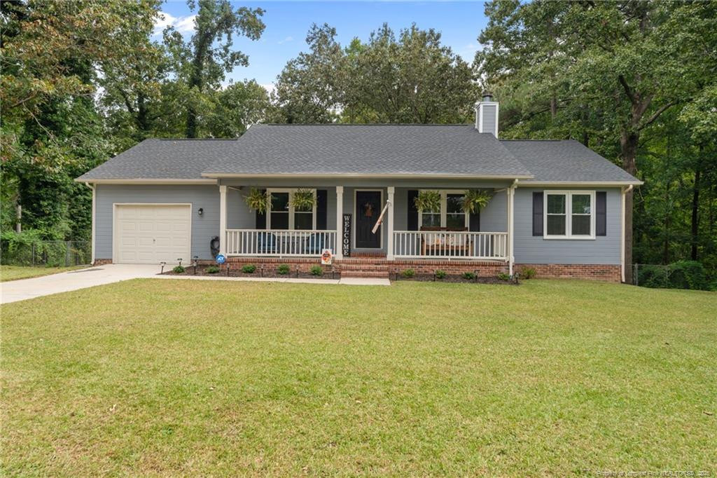 76 North Hillside Drive Spring Lake, NC 28390 - Photo 3 of 50 a front view of a house with yard and glass top table and chairs