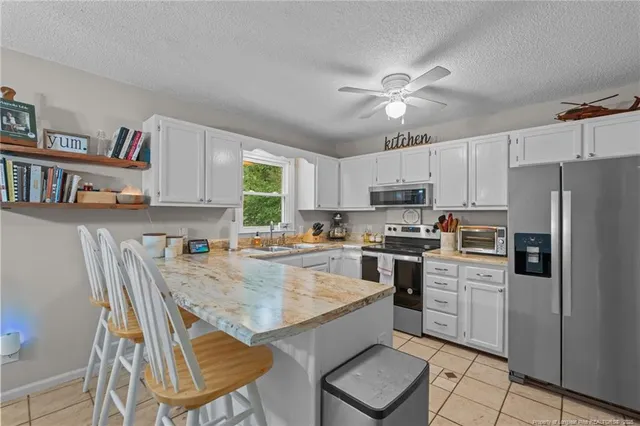 a kitchen with granite countertop a stove a sink dishwasher a refrigerator and cabinets with wooden floor