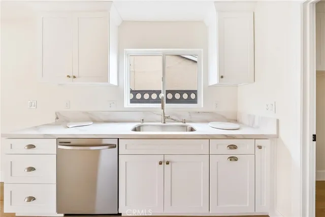 a kitchen with a white cabinets and window