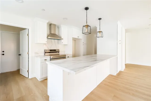 a kitchen with kitchen island white cabinets and stainless steel appliances