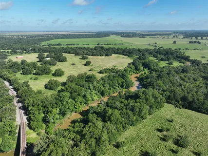 a view of a green field with lots of bushes