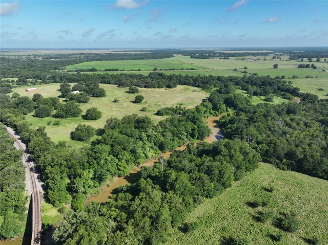 a view of a green field with lots of bushes