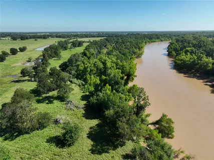 an aerial view of green landscape with trees houses and lake view