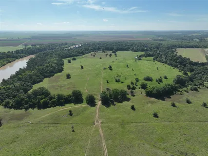an aerial view of residential houses with outdoor space and trees