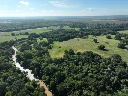 an aerial view of residential houses with outdoor space and trees