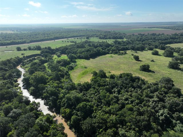 an aerial view of residential houses with outdoor space and trees
