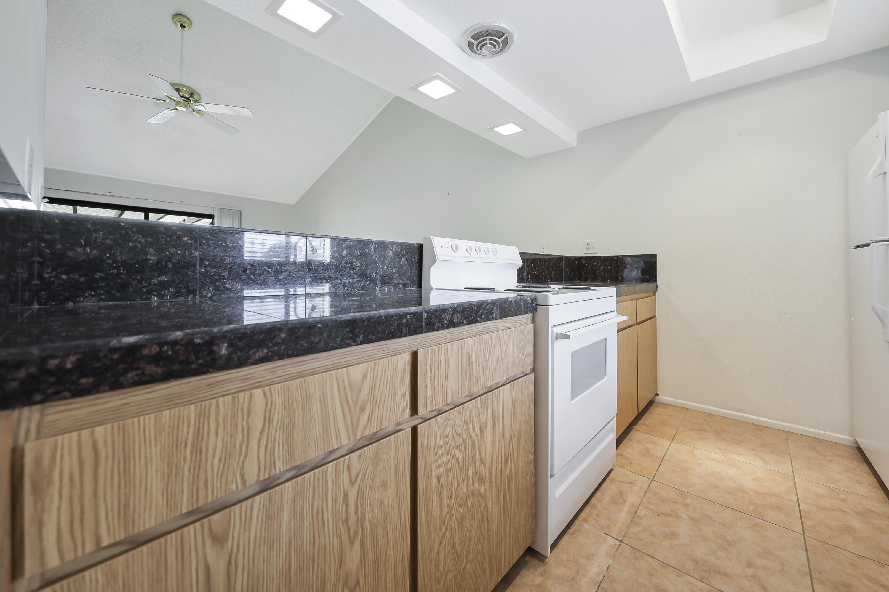 40953 Inverness Way Palm Desert, CA 92211 - Photo 7 of 41 a kitchen with granite countertop white cabinets and white appliances